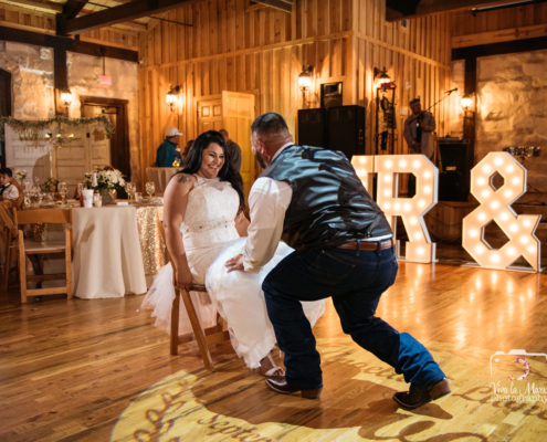 Bride has fun while groom takes her garter off